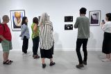 People viewing artworks from gallery exhibition