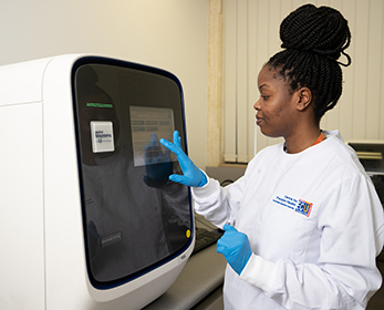 Woman in lab coat using the QuantStudio monitor