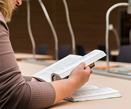 Student sitting at a desk studying from a text book