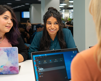 Students work collaboratively at a high table near the eLab at Joondalup Campus Library.