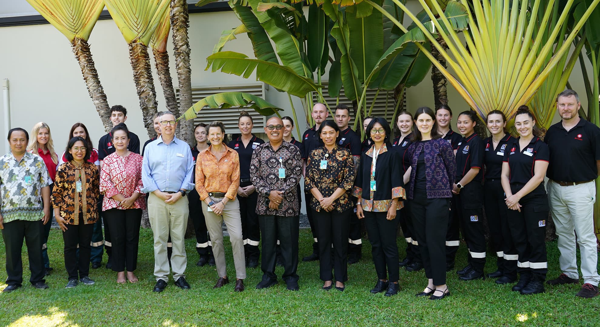 A large group of university paramedical students, Consulate officials and hospital delegates stand together outdoors in Bali.