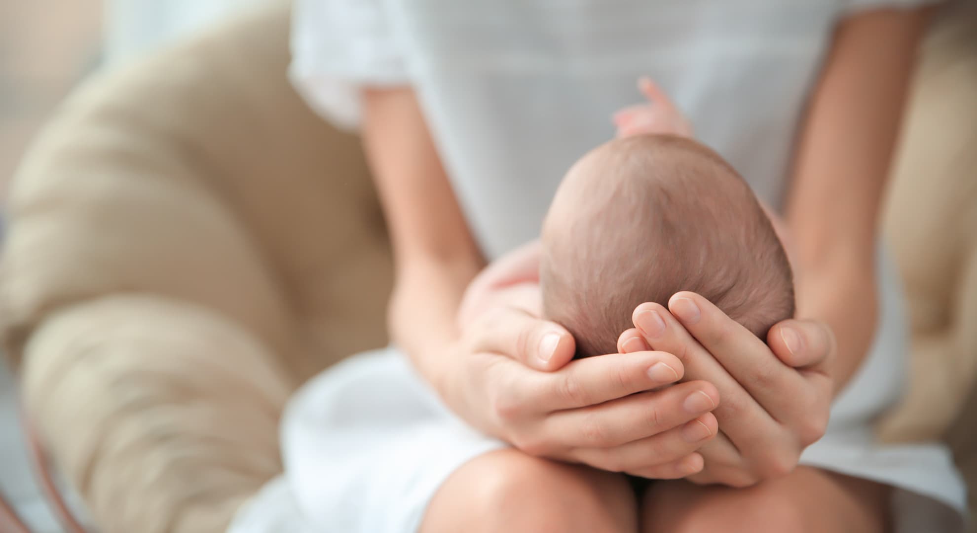 Mother holding baby in her lap.