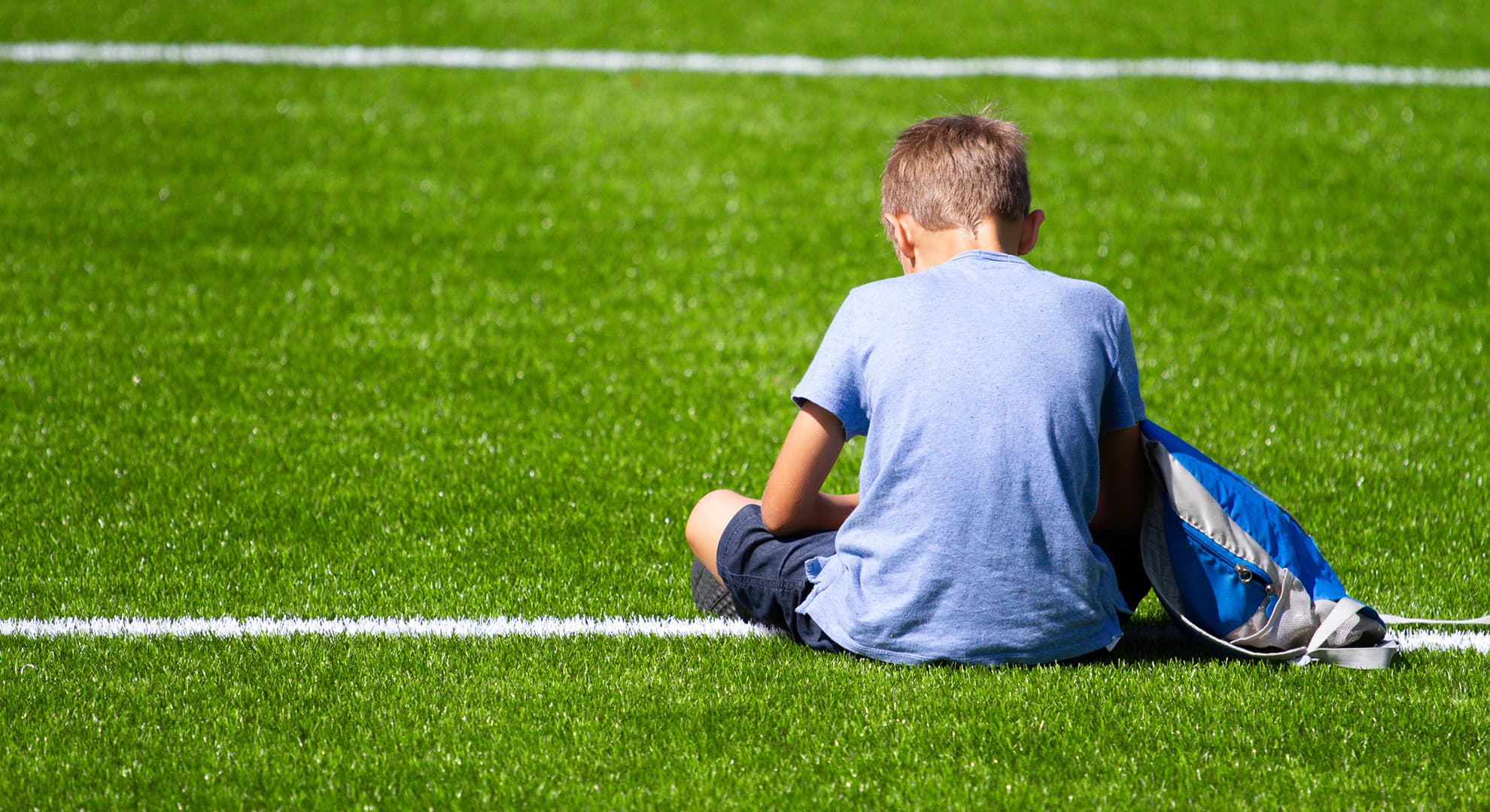 A child sits in the middle of an oval with his back to the camera