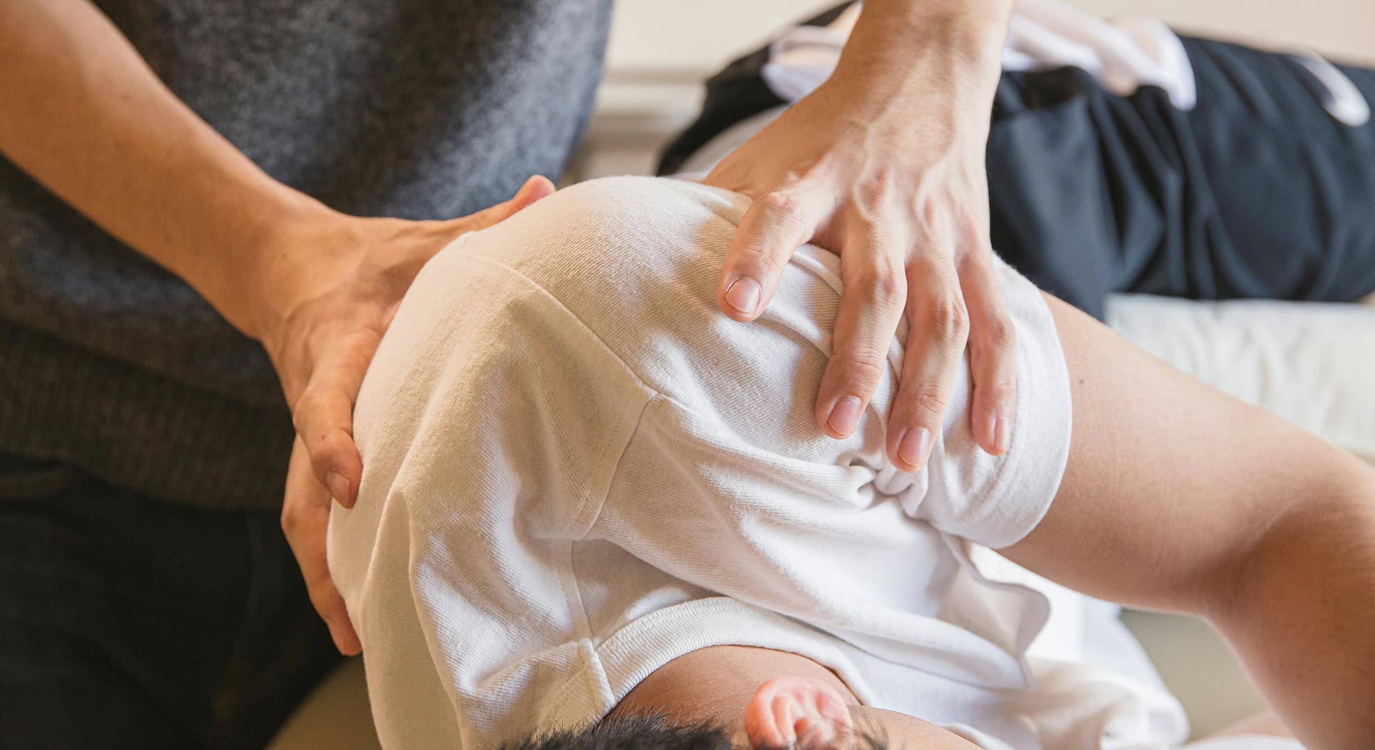 Hands massaging a shoulder.