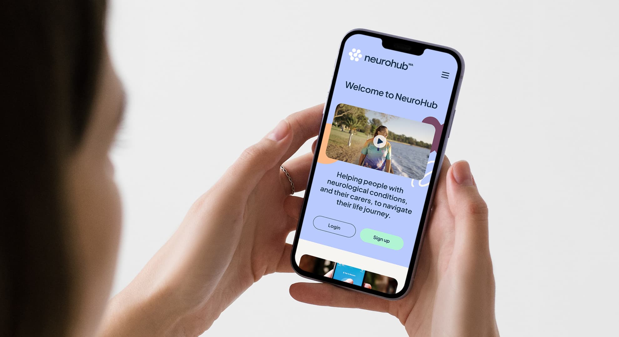 Woman holding phone with NeuroHub website.