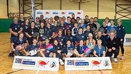 students in basketball hall gathered before large placard