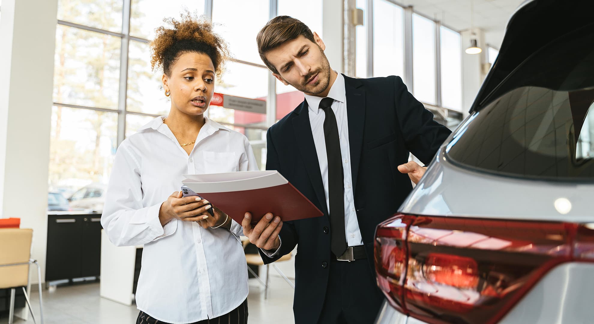 Concerned man and woman looking at a car.