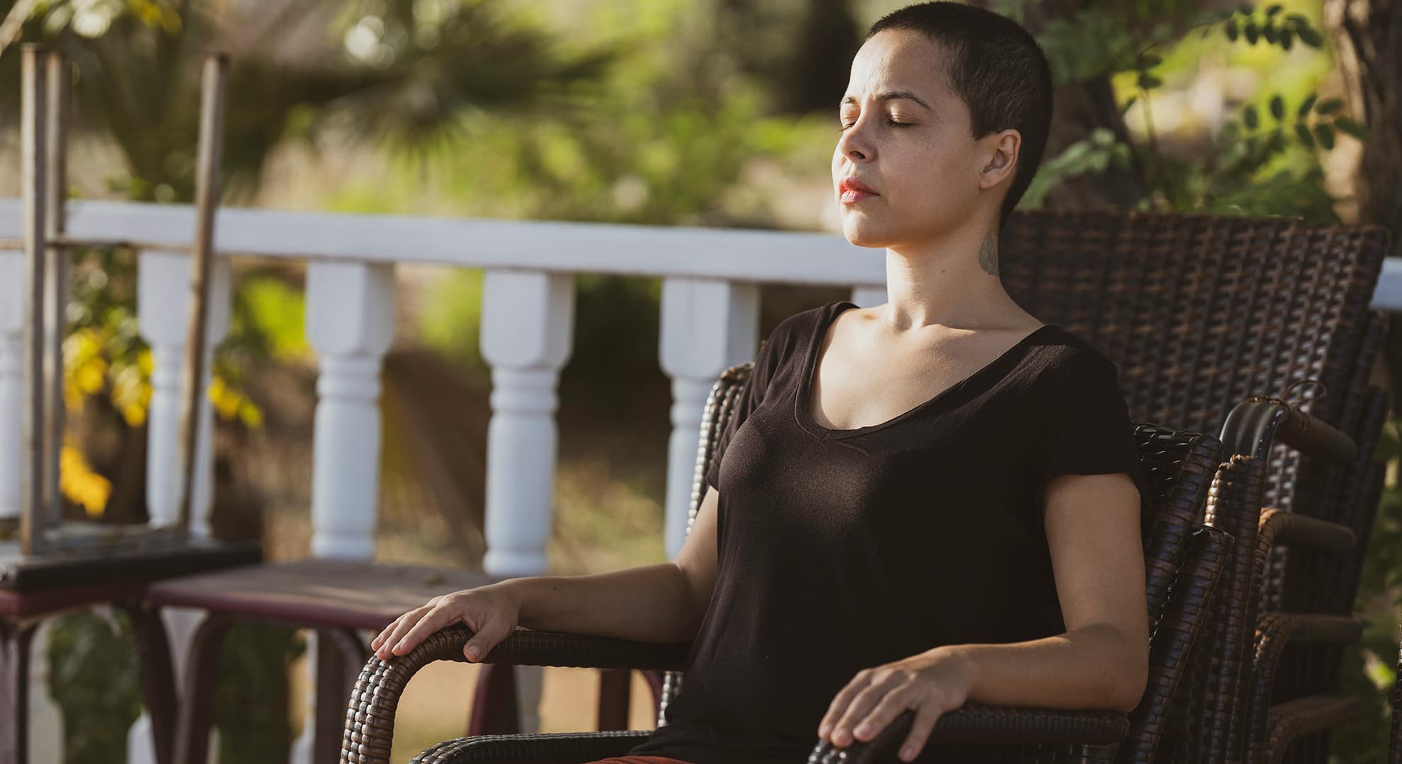 Woman sitting on a chair with her eyes closed.