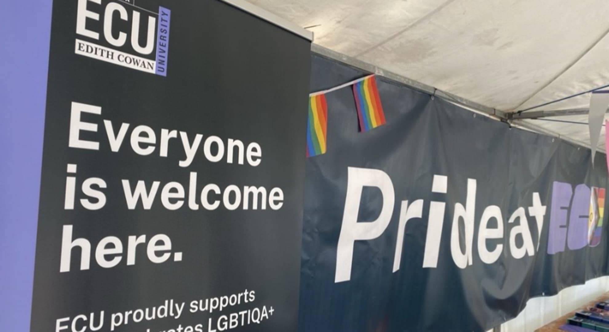 Inside a marquee stall with Edith Cowan University banners saying 'Everyone is welcome here'