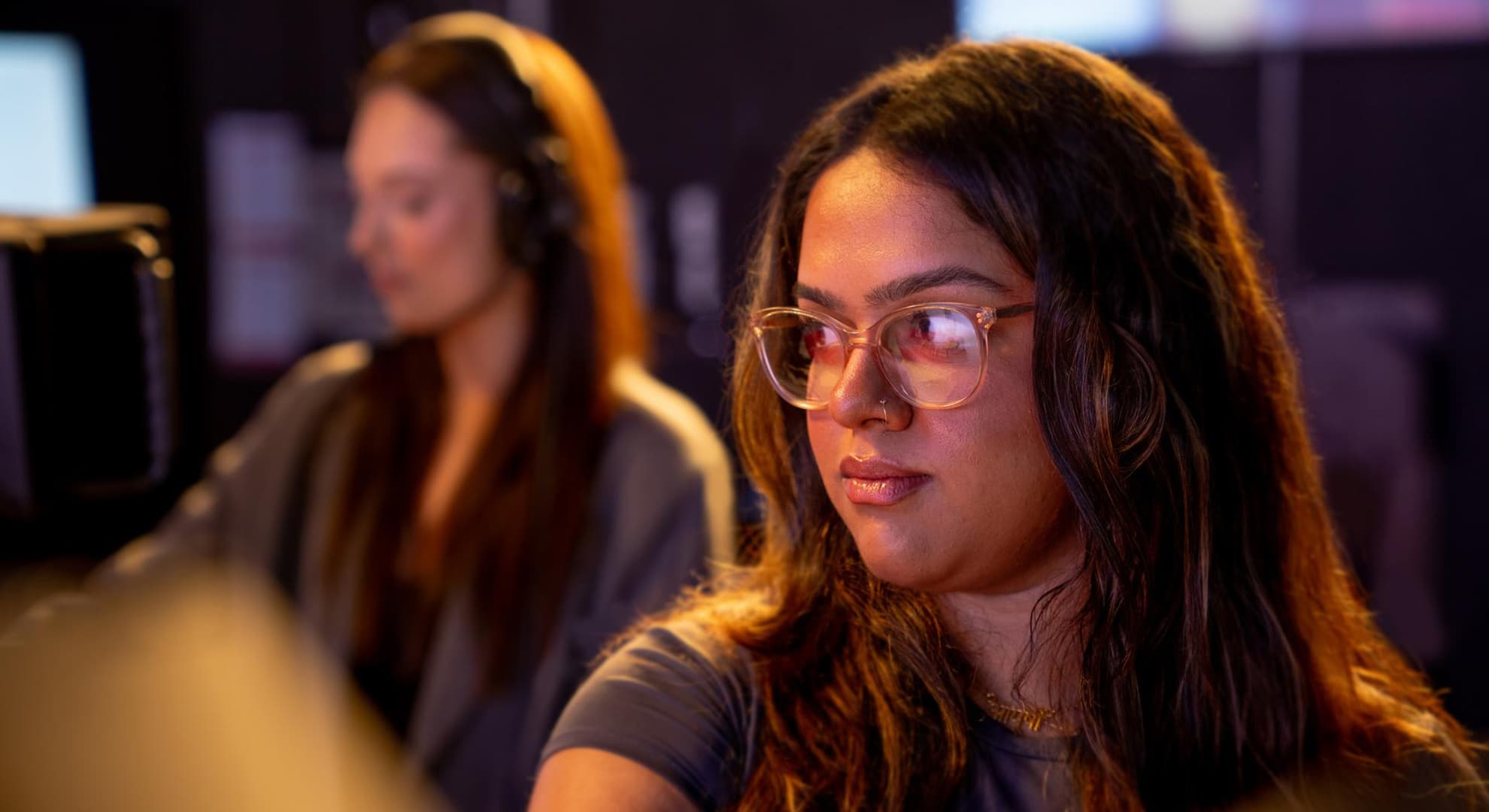 Girl sitting in front of screen.