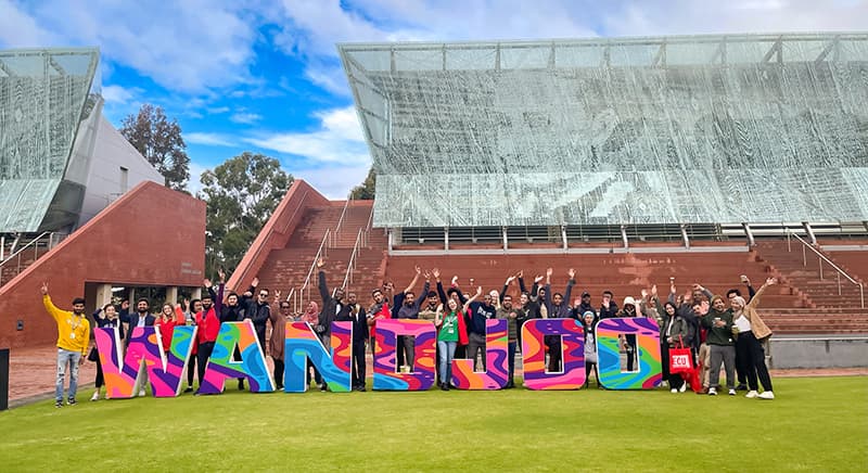 International students standing behind colourful sign that says 'Wandoo'