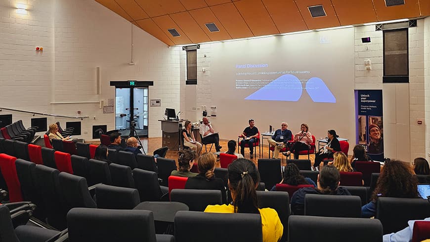 A lecture hall with an audience engaging in a panel discussion.