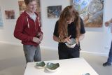 Photo of participants inspecting ceramic artwork