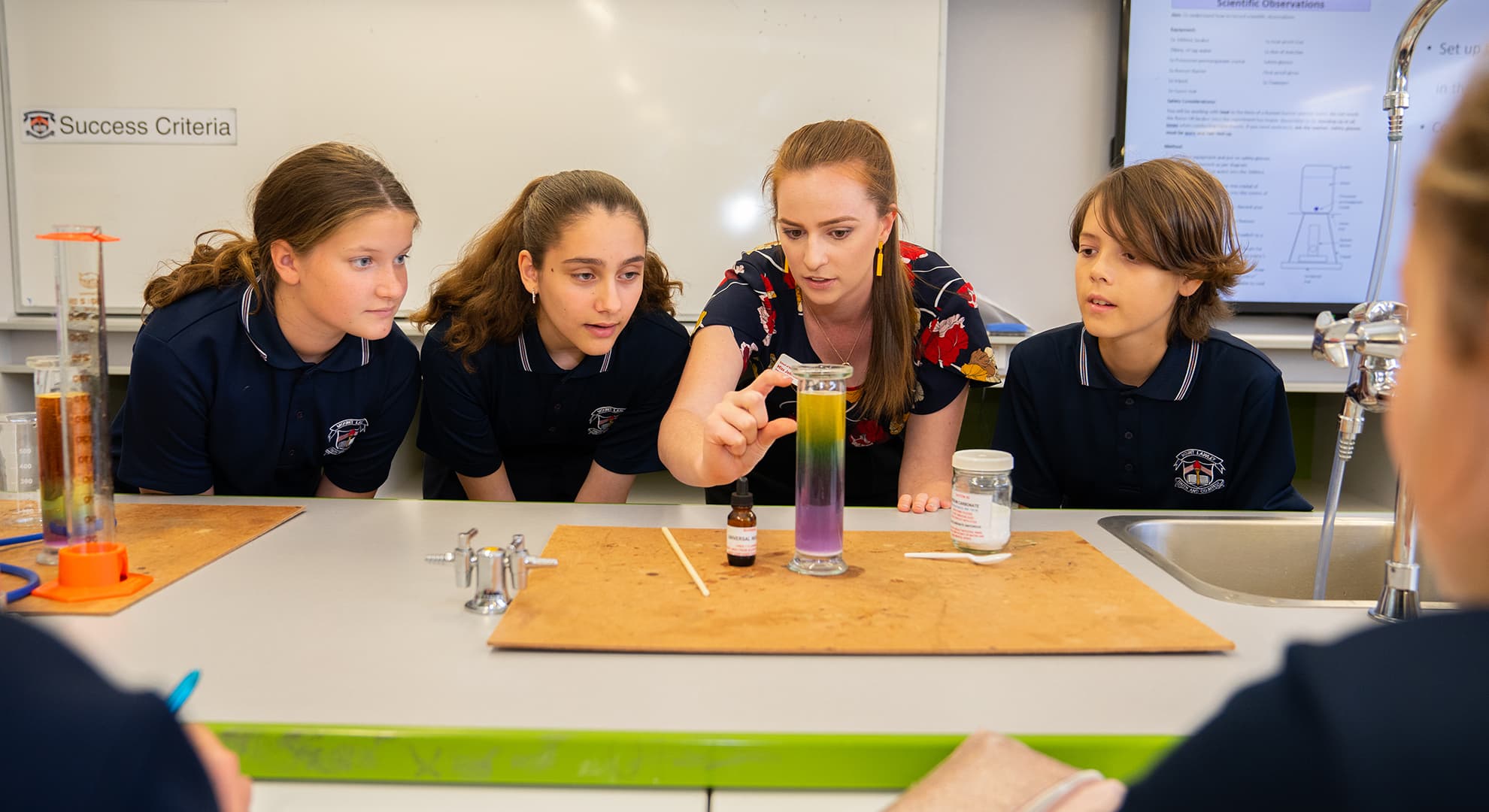 Young female science teacher with students