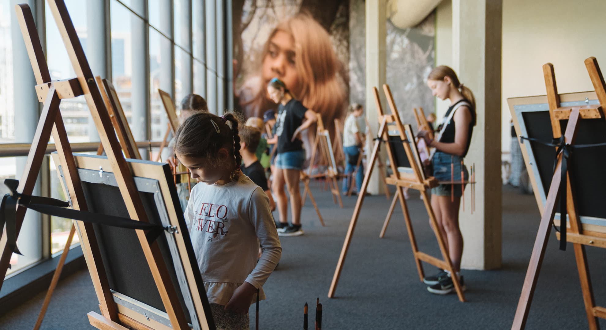 People participating in the exhibition, painting on easels.