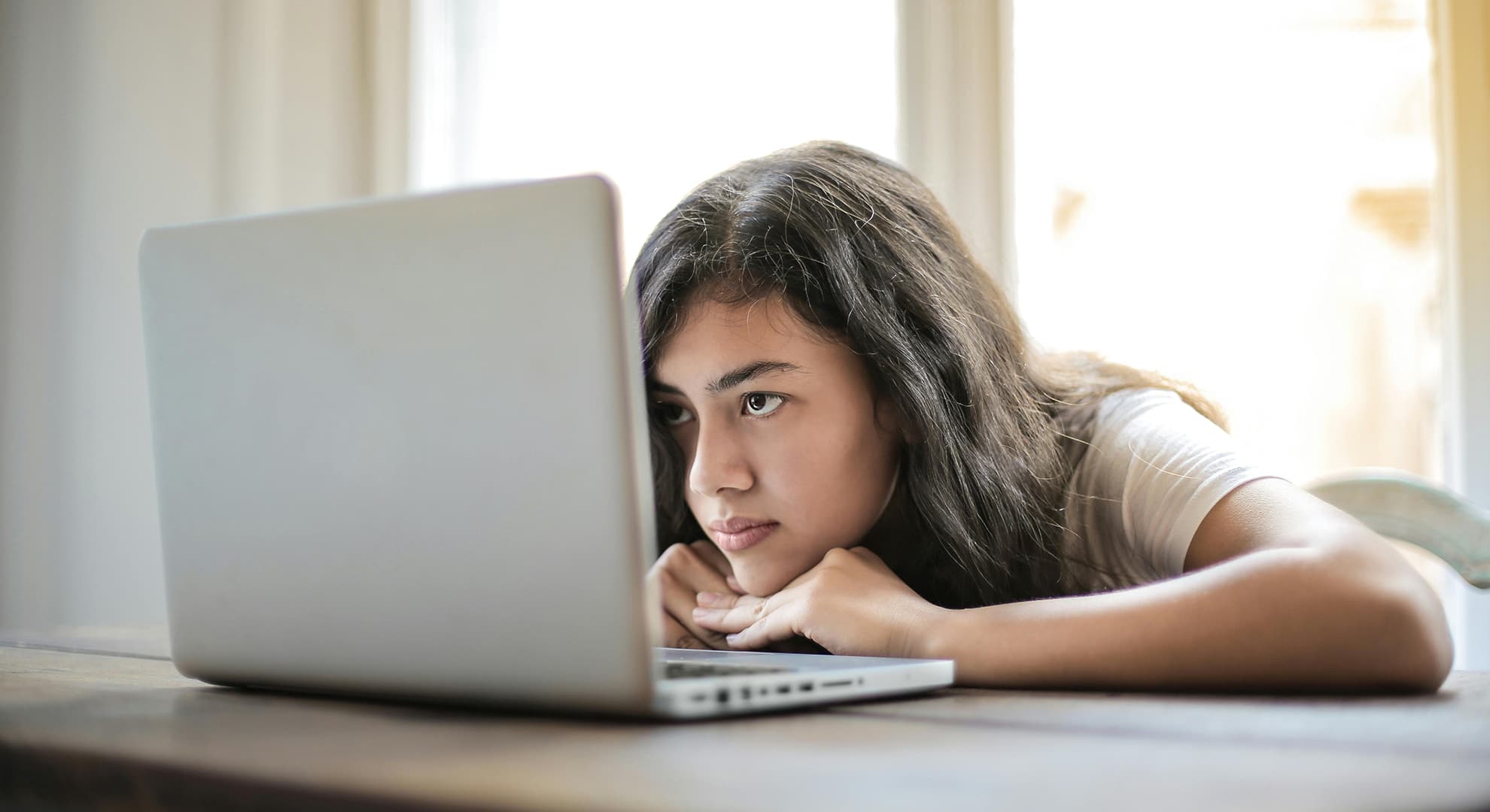 Girl staring at a laptop screen.