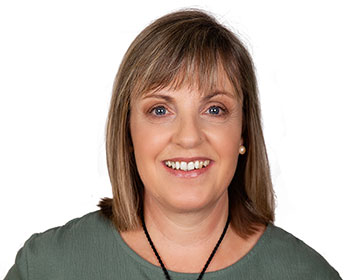 A portrait photo of Dr Jane Kirkham standing in front of a white background