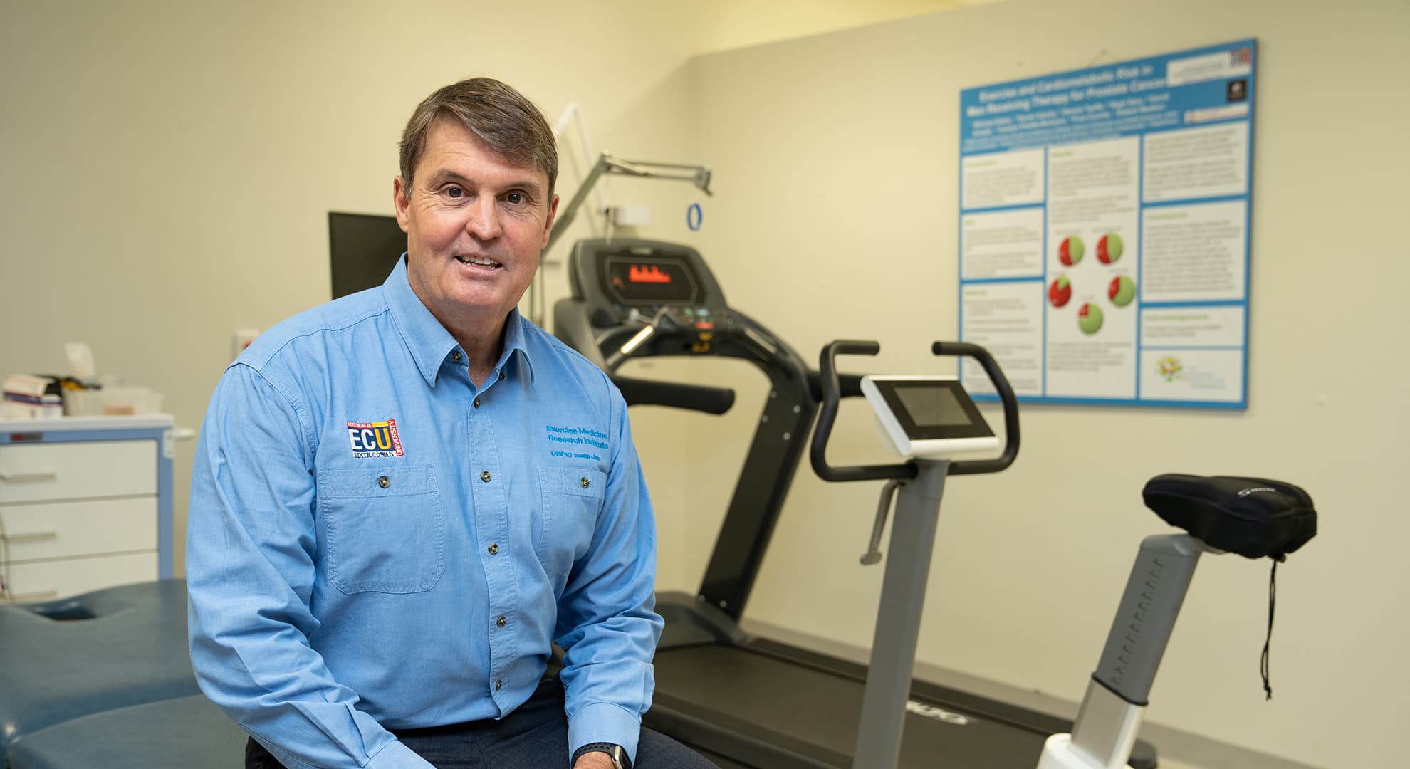 Prof Rob Newton sitting on an examination table.