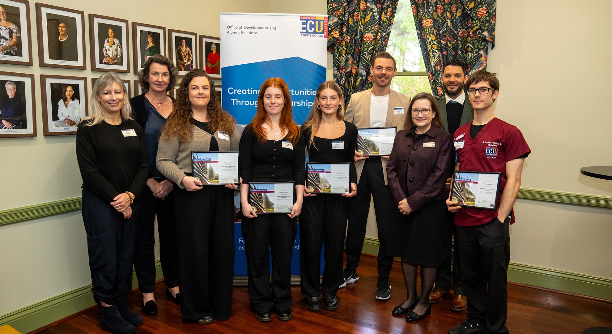 A group of ECU staff and students pose at a scholarship ceremony.