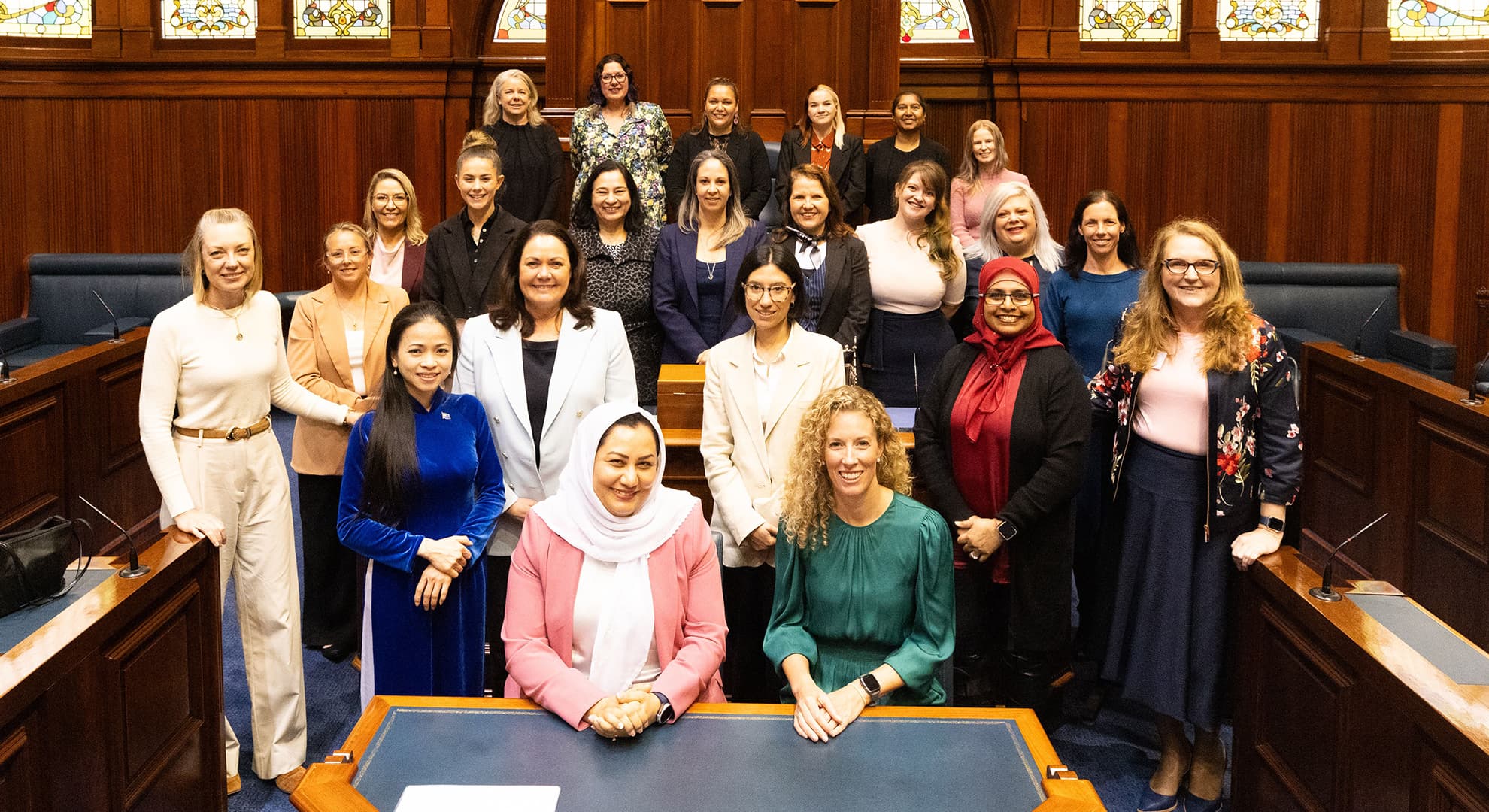 A group of women from diverse backgrounds pose for a photo in WA Parliament.