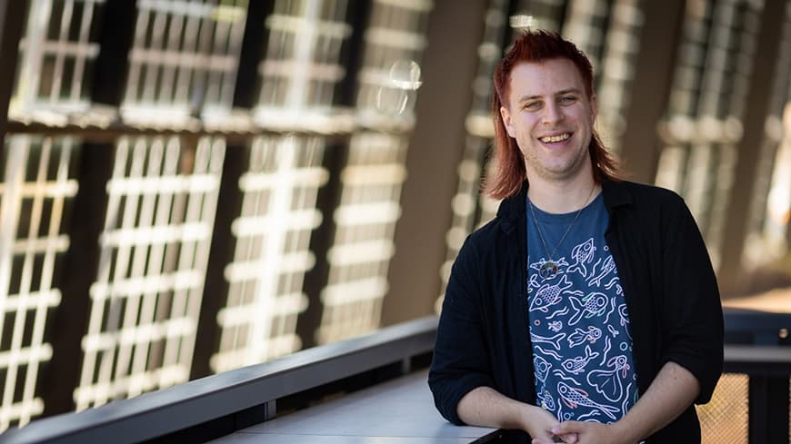 Smiling person leaning on counter in walkway