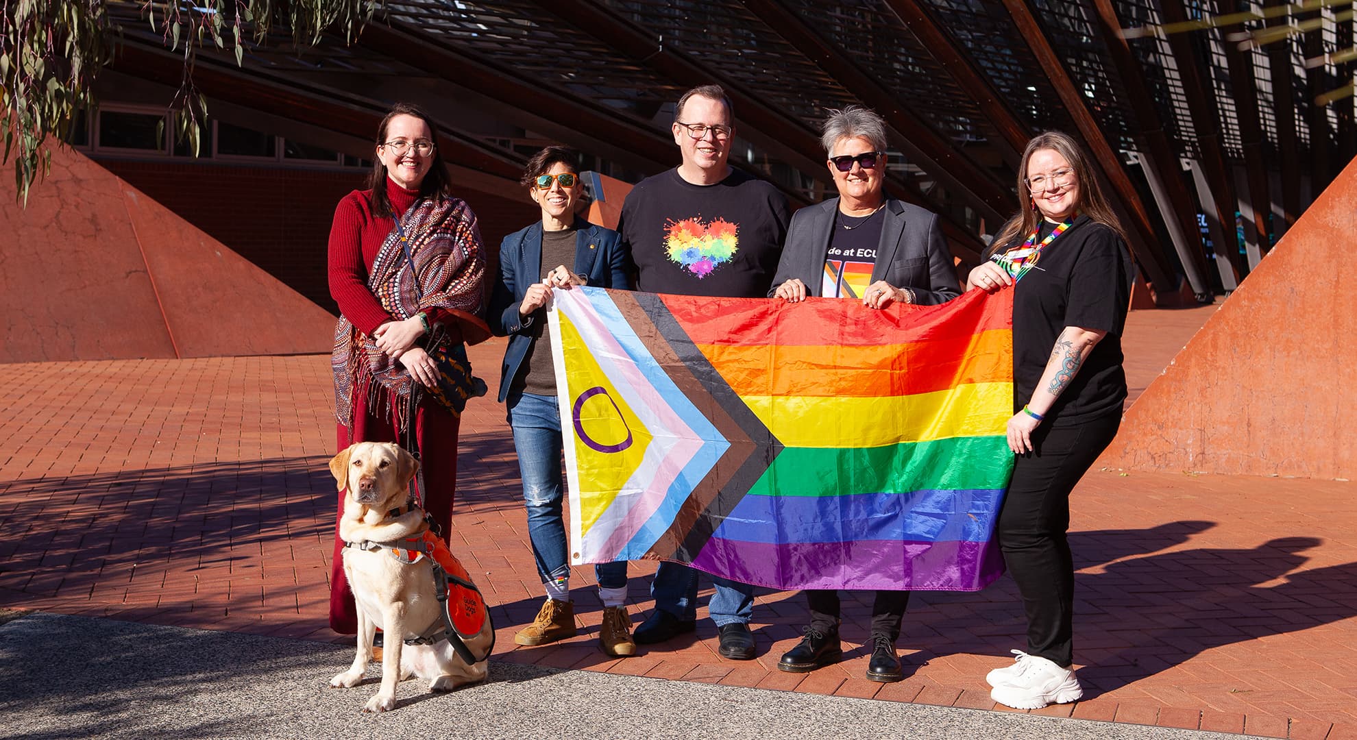 ECU staff members Heidi Apostoles with Lulu, Professor Sophia Nimphius, Graeme Watson, Michelle Rogers and Phoebe Saunders hold up the LGBTIQA+ flag.