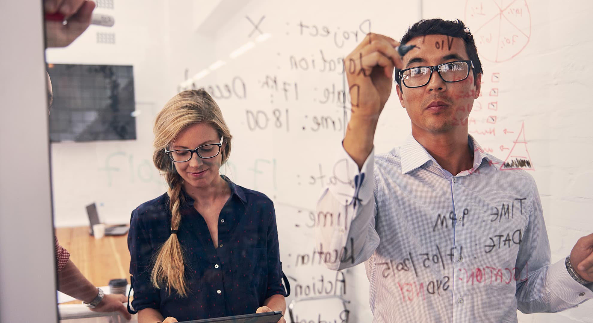 man and woman working on equation on whiteboard