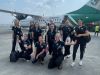 Students posing in front of airplane 