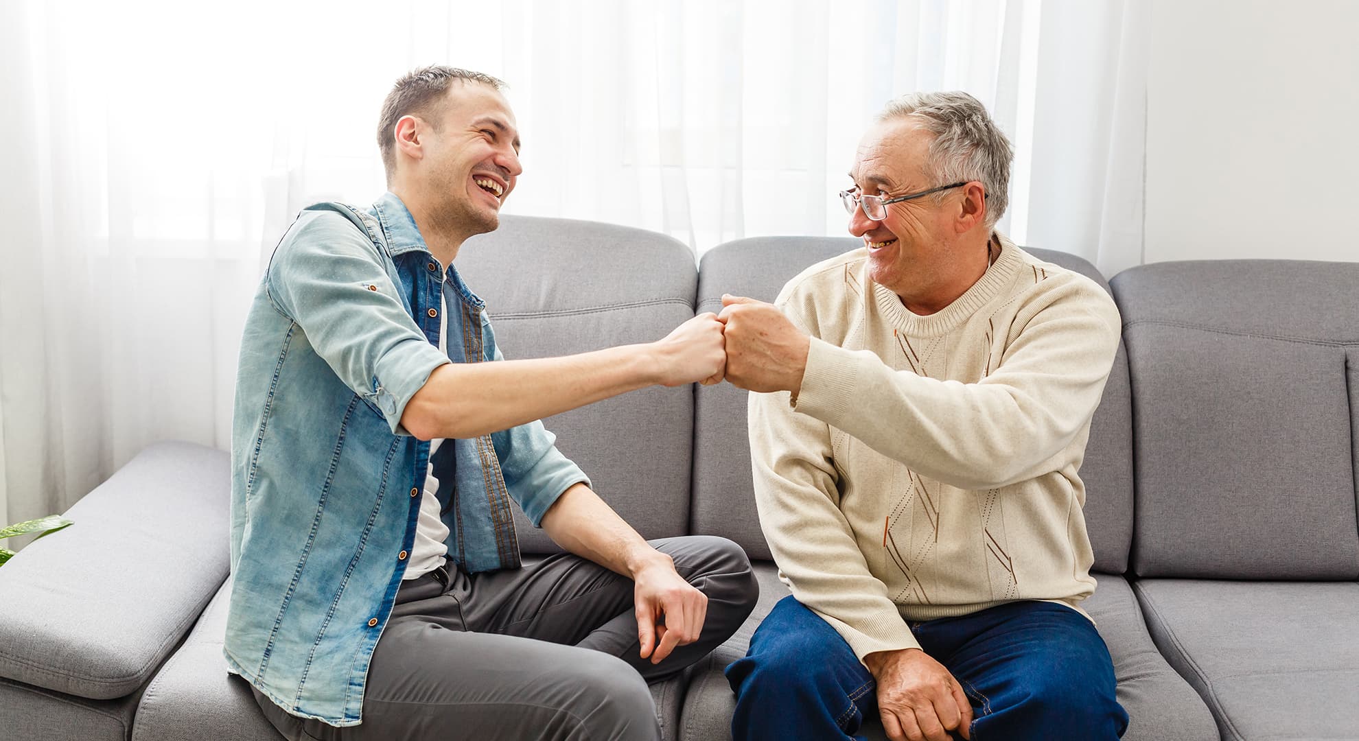 Young person and older person sitting on couch.