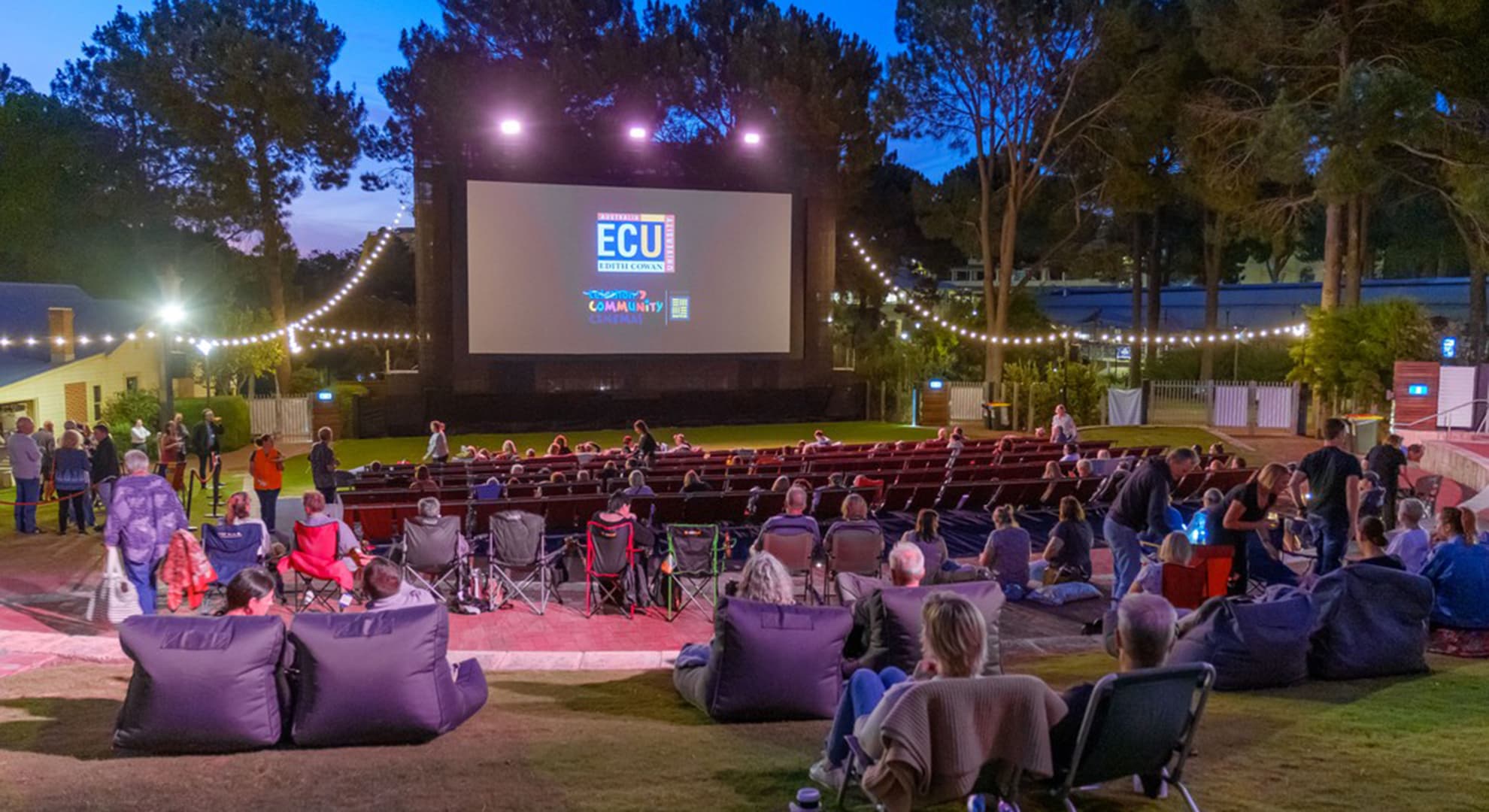 Outdoor cinema at Joondalup people sitting in deckchairs and bean bags facing the screen