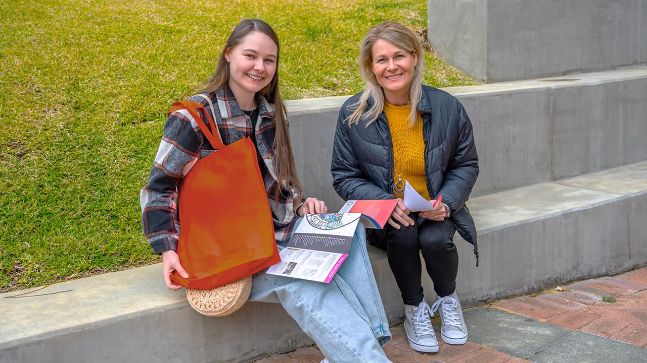 mother and daughter reading pamphlet together