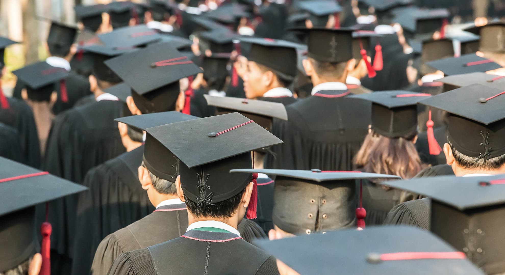 Large group of people dressed in graduation regalia.