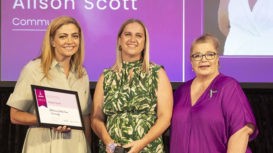 Three people standing facing camera with award certificate