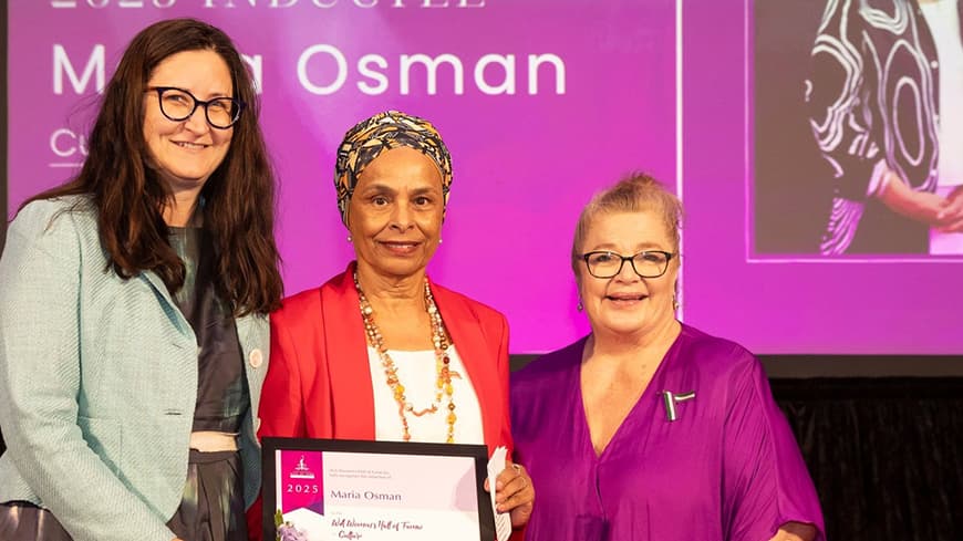 Three people standing facing camera with award certificate