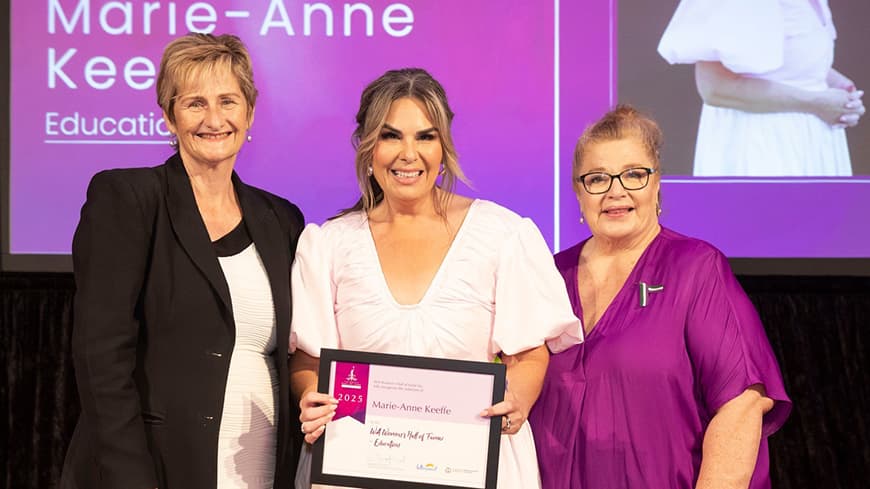 Three people standing facing camera with award certificate